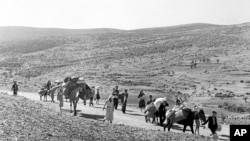 9 Kasım 1948 - Kudüs'ten Lübnan'a yürüyen bir grup Arap mülteci, yanlarında eşyalarını taşıyor.